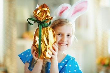 happy modern little princess looking out from easter egg