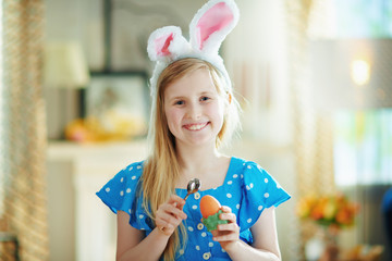 happy modern child eating easter egg with spoon