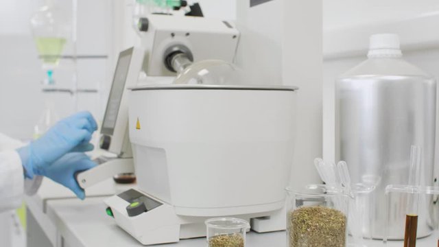 Close up of chemist extracting cbd with rotavapor in laboratory