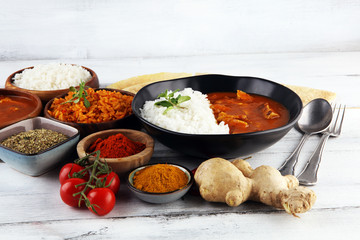Chicken tikka masala spicy curry meat food in pot with rice and naan bread. indian food on table