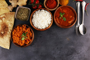 Chicken tikka masala spicy curry meat food in pot with rice and naan bread. indian food on table