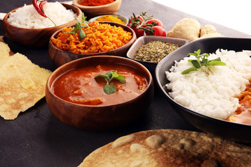 Chicken tikka masala spicy curry meat food in pot with rice and naan bread. indian food on table