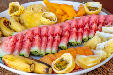 Tropical fruits on a breakfast plate, close up, top view