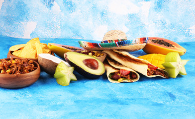 Mexican food mix in colorful colors. sombrero and mexican food with tacos