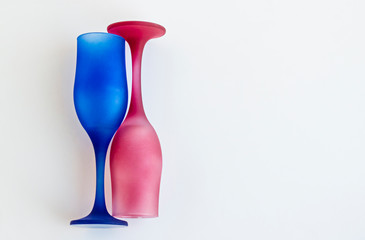 Blue and dark pink color,empty  champagne glasses designed on white with large copy space