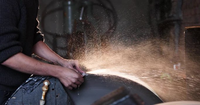 Bladesmith wet grinding a blade