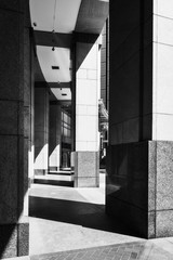 Light and shadows at the curved Arcade Entry at Chifley Plaza in Sydney CBD, Australia. The strong pillars are cladded with a a collage of exquisite stones, marbles and granite.