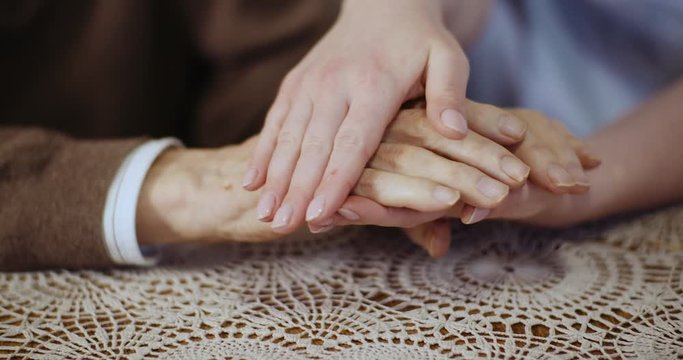 Woman touching elderly man hands and supporting Senior Man