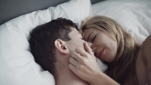 Young couple in underwear passionately kissing in morning after waking up. Intimacy moment. Love. sex, family, relations concept. Filmed on RED 4k.