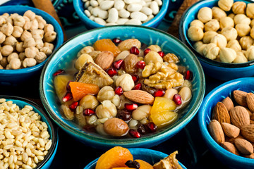 Traditional Turkish Dessert Asure or Noah's  Pudding in the stylish blue color ceramic bowls with ingredients.