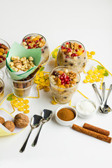 Traditional Dessert,Noah Pudding or Ashura,Asure in the glass bowls on the white surface with walnuts,cinnamon sticks,handmade lace napkin and hazelnuts.Conceptual image of Asure Day.