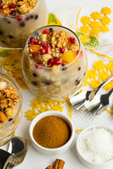 Traditional Dessert,Noah Pudding or Ashura,Asure in the glass bowls on the white surface with walnuts,cinnamon sticks,handmade lace napkin and hazelnuts.Conceptual image of Asure Day.