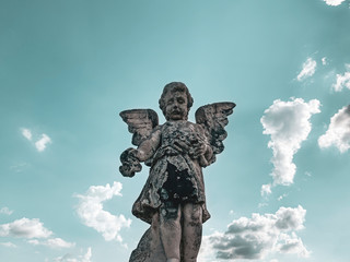 statue of an angel on background of blue sky