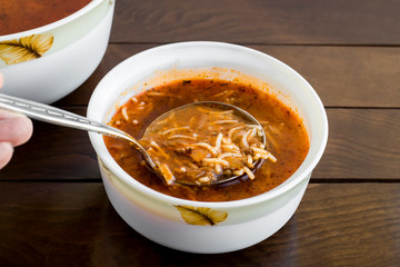 Traditional Turkish Vermicelli Soup, serving with metal ladle, on wooden table