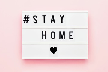 STAY HOME written in light box on pink background. Healthcare and medical concept. Top view....