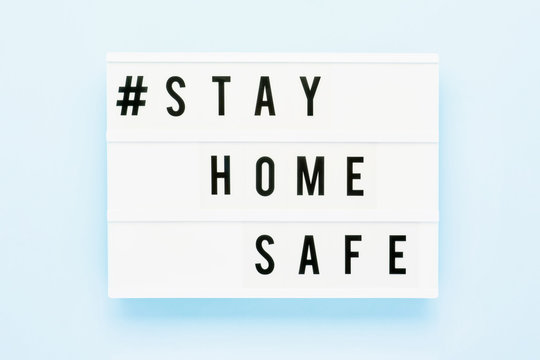 STAY HOME SAFE Written In Light Box On Blue Background. Healthcare And Medical Concept. Top View. Quarantine Concept.