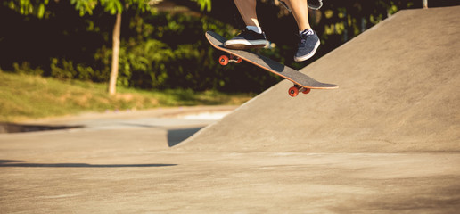 Skateboarder legs skating at skatepark
