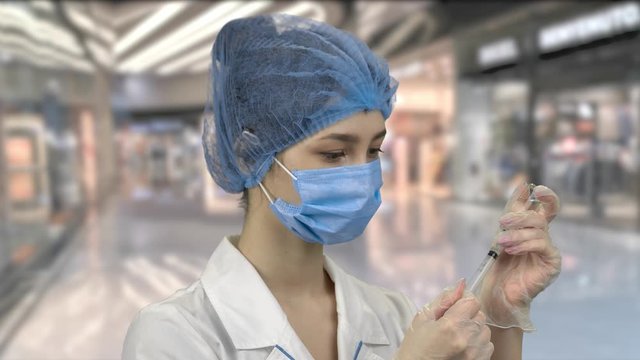 Young doctor with syringe pulling medicine. Prepare to make the injection.