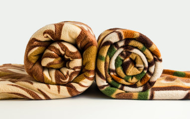 Different size and color fleece blanket rolled on the white background