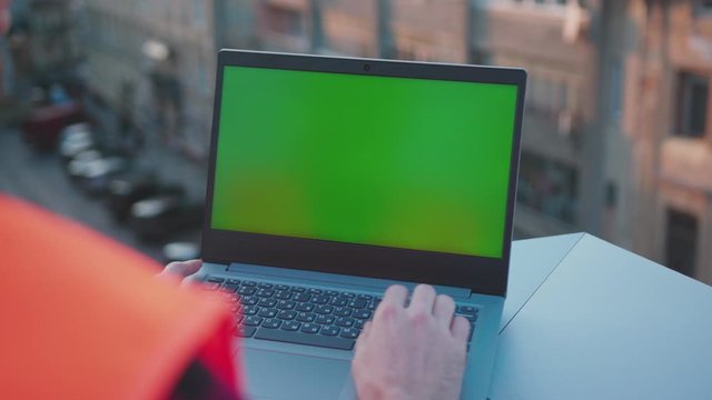 Slow motion hands engineer using laptop computer with green screen on balcony worker project occupation builder technology mock-up professional male safety device computer close up