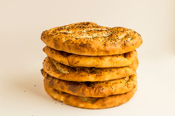 Fresh,Round Ramadan Breads stacked on white with copy space.