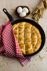 Traditional Ramadan Bread,pide in the black color pan with red fabric napkin,egg and wheat ears.