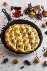 Traditional Ramadan Bread,pide in the black color pan with dry date fruits,olives and tea.