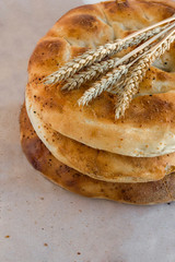 Fresh Ramadan Breads stacked on craft paper surface with wheat ears.