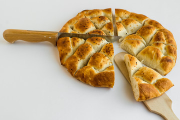 Triangle sliced Ramadan bread,pide on the wooden tray with spatula and knife.