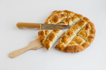 Triangle sliced Ramadan bread,pide on the wooden tray with spatula and knife.