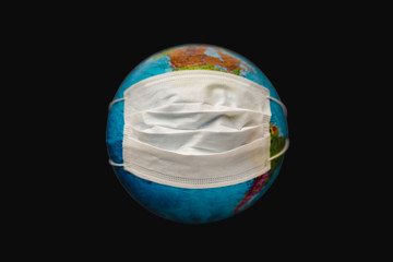 Globe in a medical mask on a black background