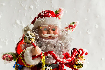 The Santa Claus Toy is in snowy with Christmas gifts,Merry Christmas or new year concept.
