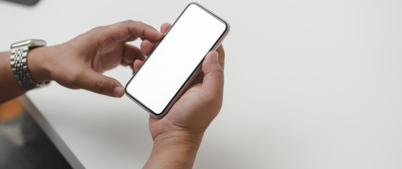 Cropped shot of male entrepreneur using mock-up smartphone