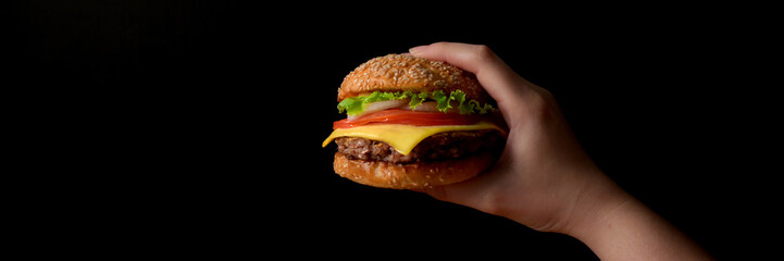 Close up view of a woman holding beef burger ready to eat