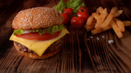 Close up view of beef burger with French fries, ingredients and copy space