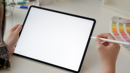 Cropped shot of female designer working on mock-up tablet with stylus pen