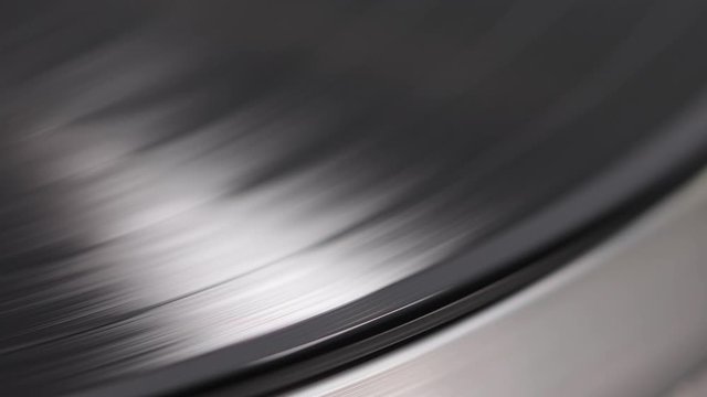 Close up of turntable needle on a vinyl record. Turntable playing vinyl. Needle on rotating black vinyl.