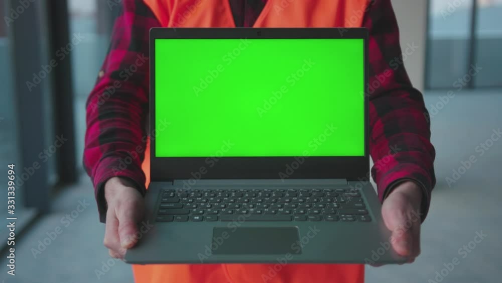 Wall mural close up laptop computer with green screen man hold engineer inside building worker project occupati