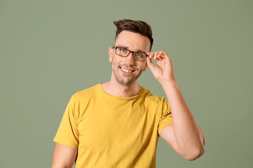 Young man wearing eyeglasses against color background