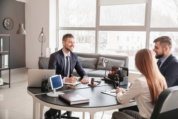 Male lawyer working with clients in office