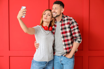 Obraz premium Couple taking selfie on color background