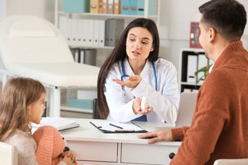Obraz premium Man with little daughter visiting pediatrician in clinic