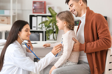 Obraz premium Man with little daughter visiting pediatrician in clinic