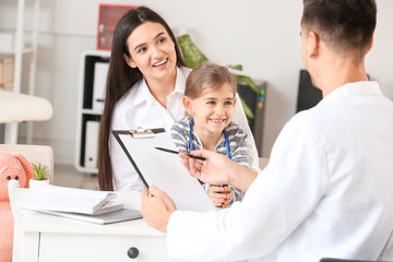 Woman with little daughter visiting pediatrician in clinic