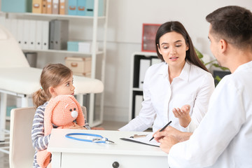 Woman with little daughter visiting pediatrician in clinic