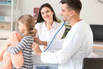 Woman with little daughter visiting pediatrician in clinic