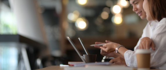 Side view of two businesspeople brainstorming on their work with laptop computer