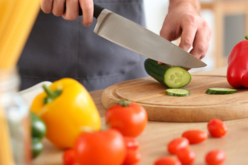 Handsome male chef cooking in kitchen, closeup