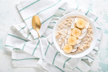 Bowl with tasty sweet oatmeal on color background