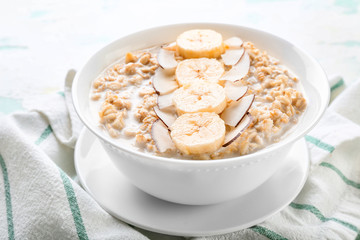 Bowl with tasty sweet oatmeal on table